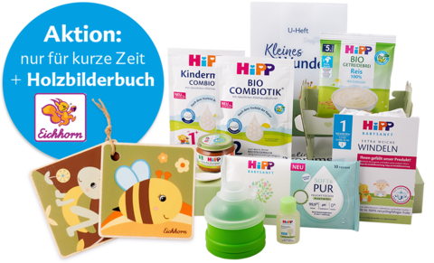 Eine Reihe von Babypflegeprodukten der Marke Hipp, darunter eine Babyflasche, eine Sprühflasche, ein Nasenspray und einige andere Artikel, begleitet von einem Werbebanner von Eichhorn, das ein kostenloses Holzbilderbuch bei einem Kauf anbietet.